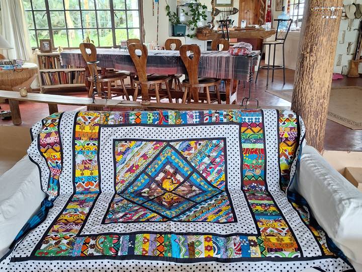 A kanga patchwork quilt draped over a sofa